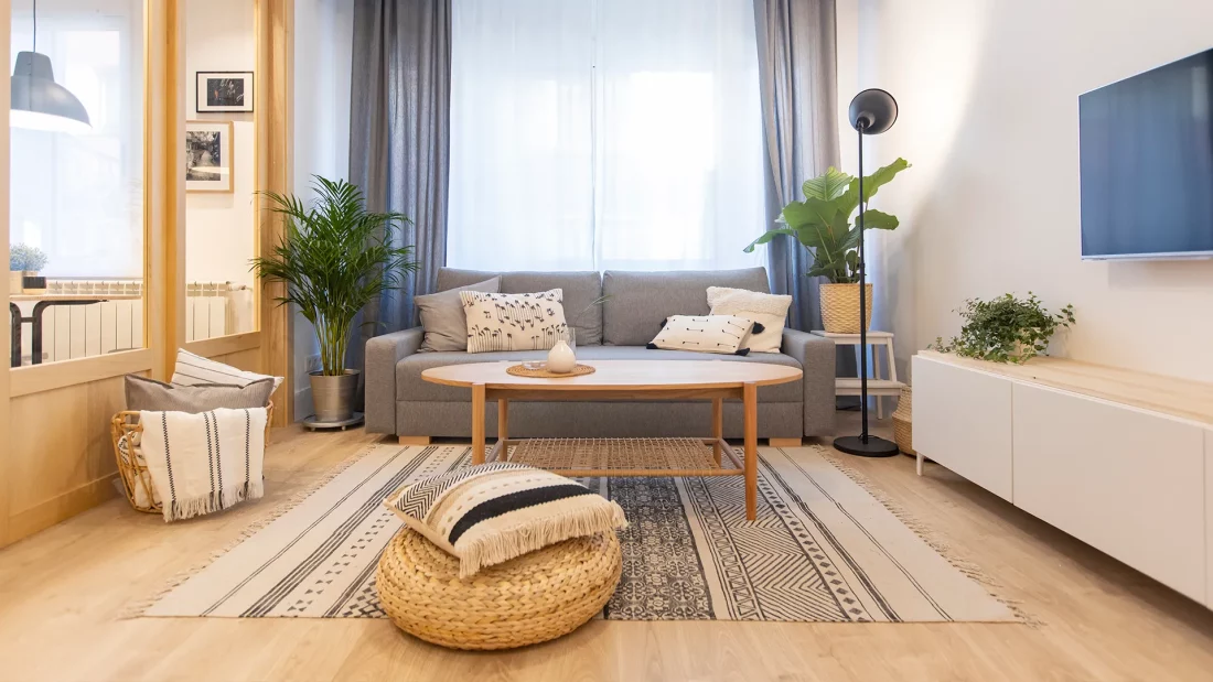 Vista de salón decorado con muebles funcionales de madera en tonos neutros